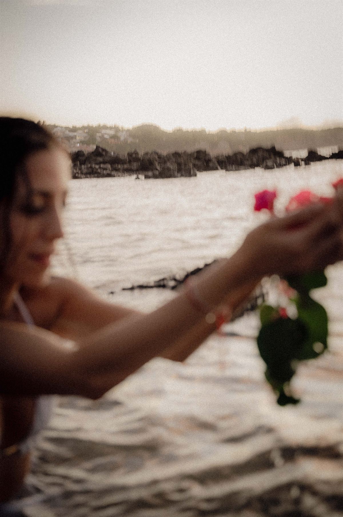 Flores na mão, à beira do mar